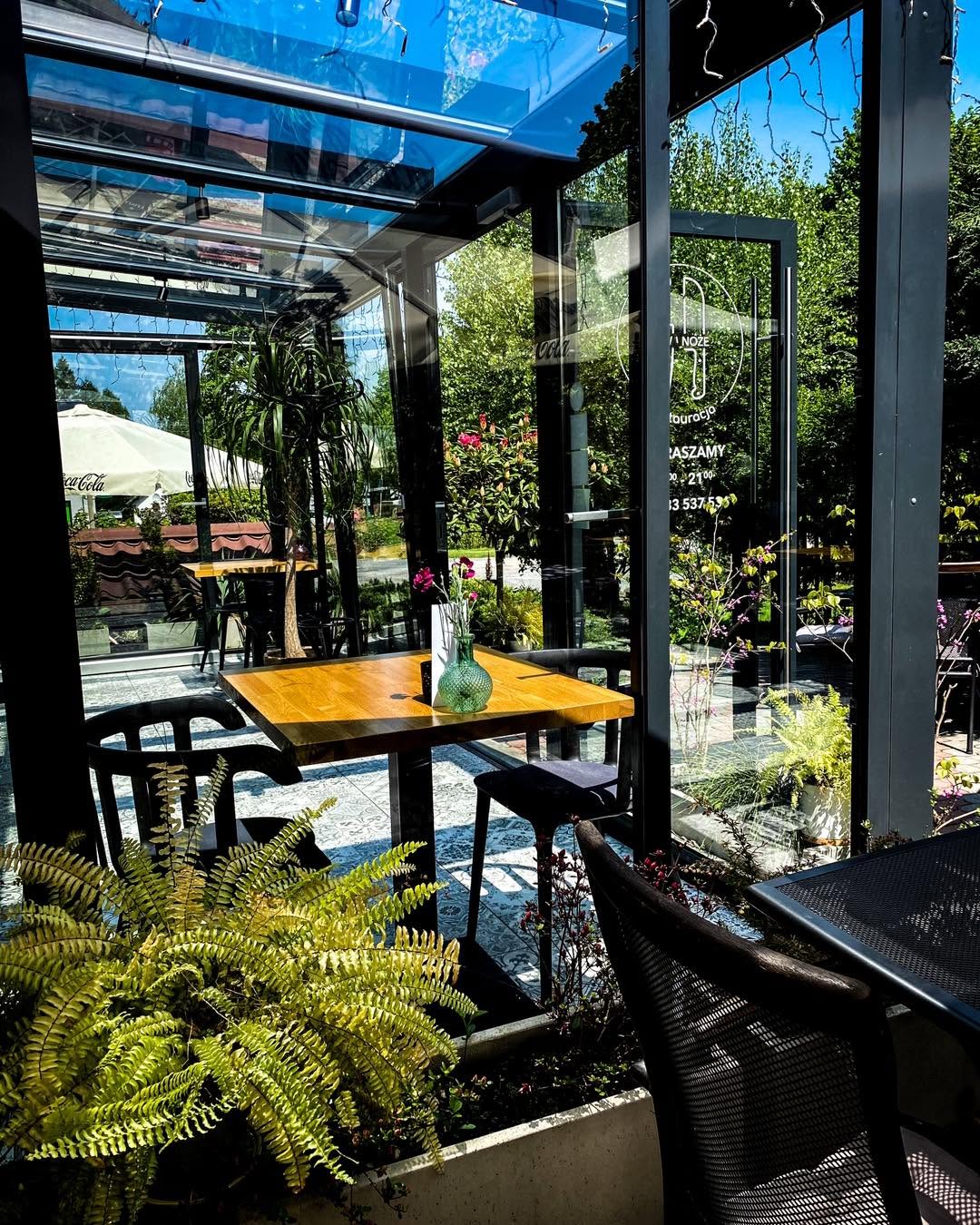 Ogród restauracji o zmierzchu z girlandami żarówek